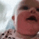 a close up of a baby 's face with its mouth open .