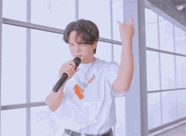 a man is singing into a microphone with his mouth open