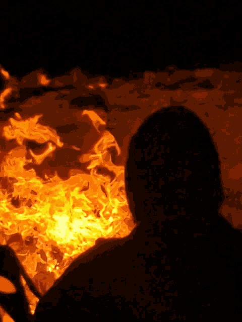 a person sitting in front of a large fire