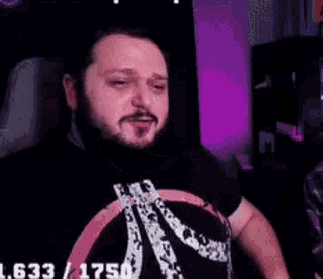 a man with a beard is sitting in a chair with his tongue hanging out while playing a video game .