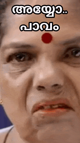 a close up of a woman 's face with a red dot on her forehead and a caption in a foreign language