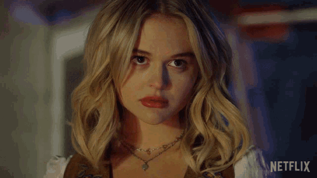 a close up of a blonde woman with a netflix logo in the corner