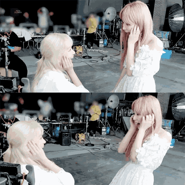 a woman with pink hair is covering her ears while another woman looks on