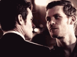 two men in suits are looking at each other with their eyes closed