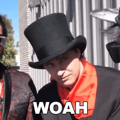 a man wearing a top hat and a red scarf has woah written on his face