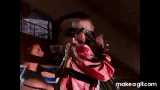 a man is holding a doll and singing into a microphone while wearing sunglasses .
