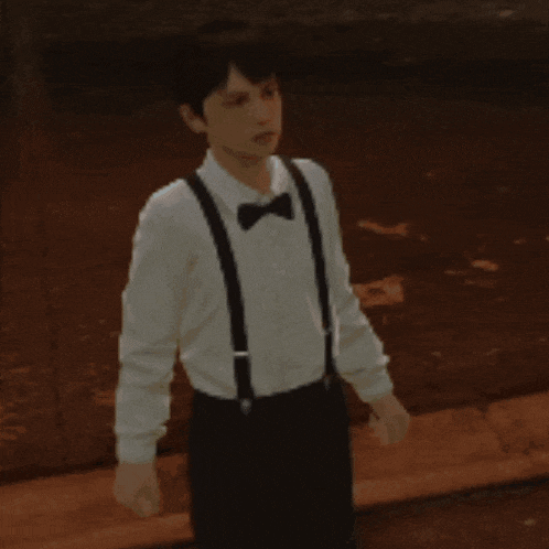 a man in a white shirt and black suspenders