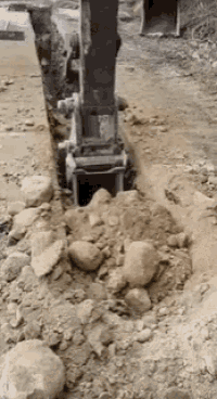 a bulldozer is digging a hole in the dirt .