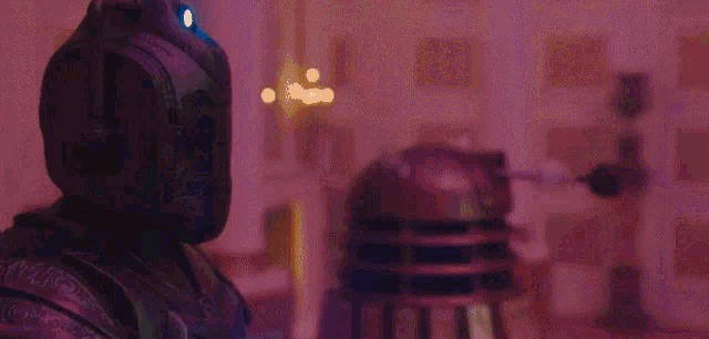 a man in a mask is standing next to a robot in a room .