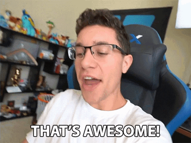 a man with glasses says that 's awesome while sitting in a chair