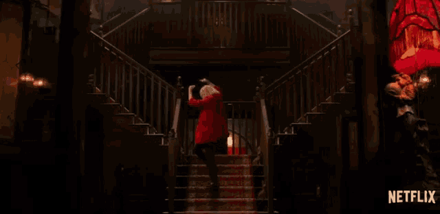a woman in a red jacket is walking down a set of stairs with a netflix logo in the corner