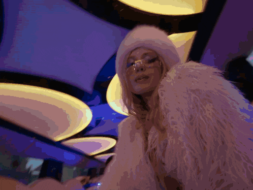 a woman wearing a white fur coat and a cowboy hat