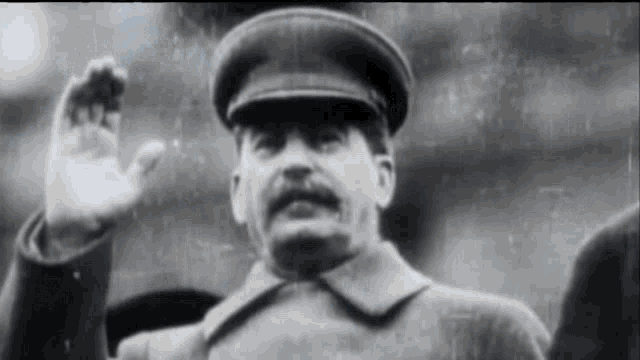 a black and white photo of a man wearing a hat and coat