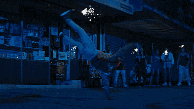 a man is doing a handstand in front of a store that sells cosmetics