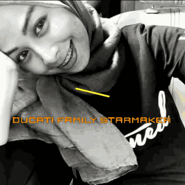 a woman wearing a hijab and a ducati family starmaker shirt smiles for the camera