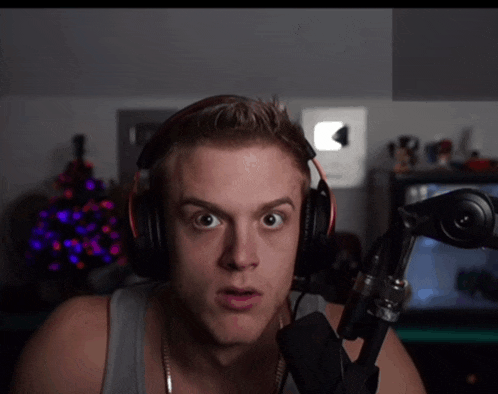a man wearing headphones and a microphone looks at the camera