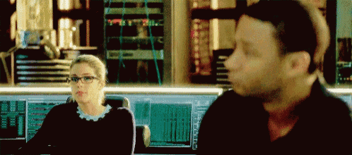 a man and a woman are looking at each other in a room