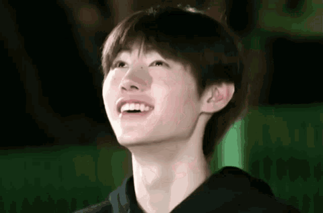 a close up of a young man 's face with a smile on his face