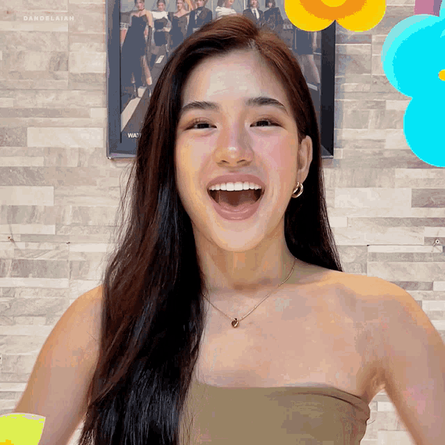a woman is laughing in front of a picture that says dandelahan