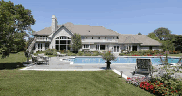 a large white house with a large swimming pool in the backyard