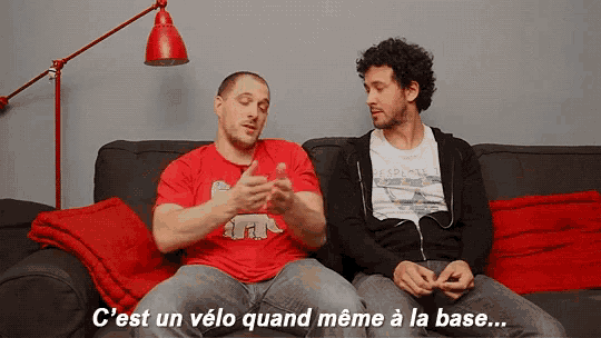 two men sitting on a couch with the words c'est un velo quand meme a la base on the bottom