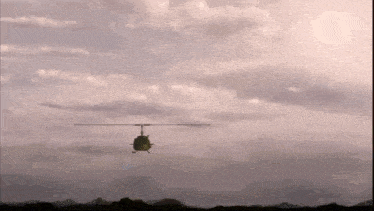 a helicopter is flying in the sky with mountains in the background