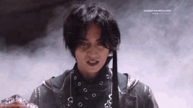 a man in a kamen rider saber outfit stands in front of a smokey background