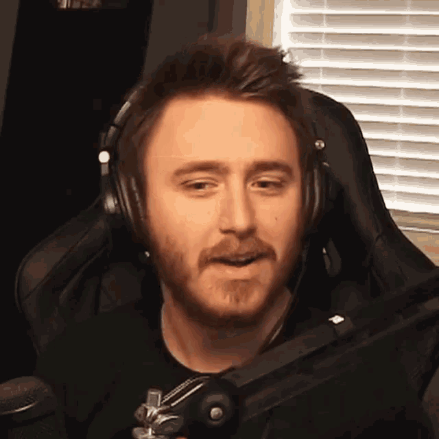 a man with a beard is wearing headphones and a microphone