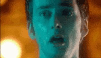 a close up of a man 's face with a blue light shining on it