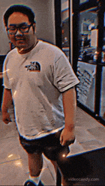 a man wearing a north face shirt is walking