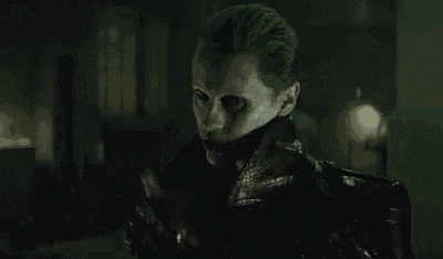 the joker from the movie suicide squad is wearing a leather jacket and gloves .