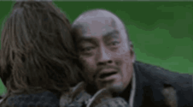 a man and a woman are hugging and the man says perfect on his face .