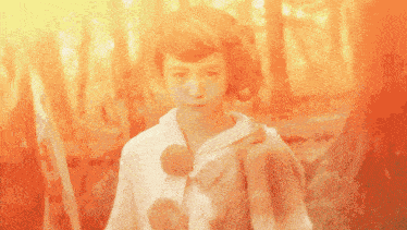 a girl in a fur coat stands in the woods looking at the camera