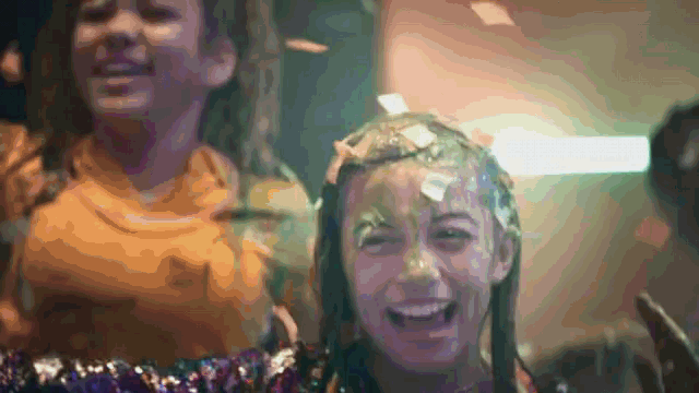 a girl with a lot of confetti on her head is smiling