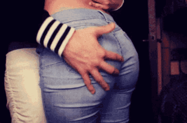 a man touches a woman 's butt with his hand