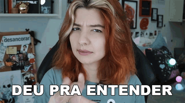 a woman with red hair says " deu pra entender " while sitting in a chair