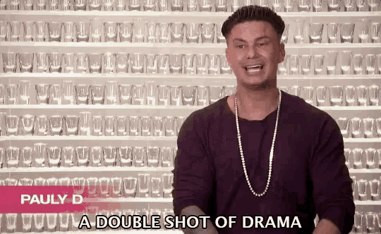 pauly d says a double shot of drama in front of a wall full of shot glasses