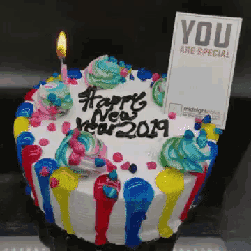 a cake that says happy new year 2019 with a candle on it