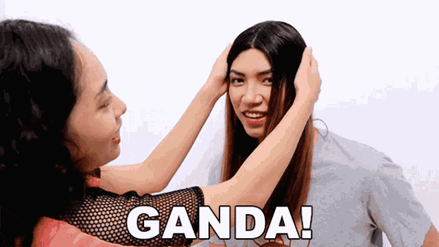 a woman is touching another woman 's hair with the word ganda written on the bottom