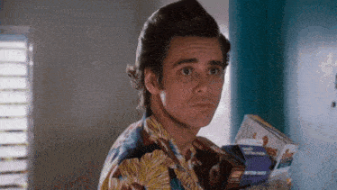 a man in a hawaiian shirt is holding a box of kraft dinner pieces