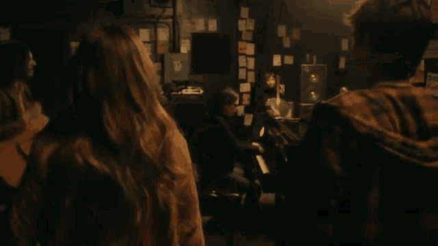 a man wearing glasses is playing a guitar with a man in a suit behind him