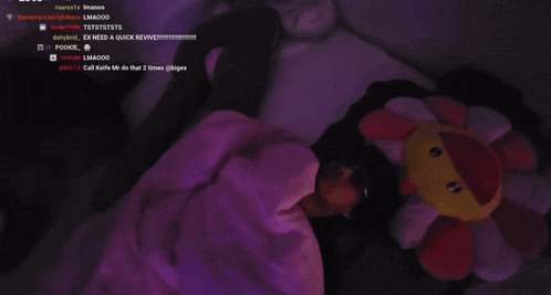 a person laying under a purple blanket with a purple background