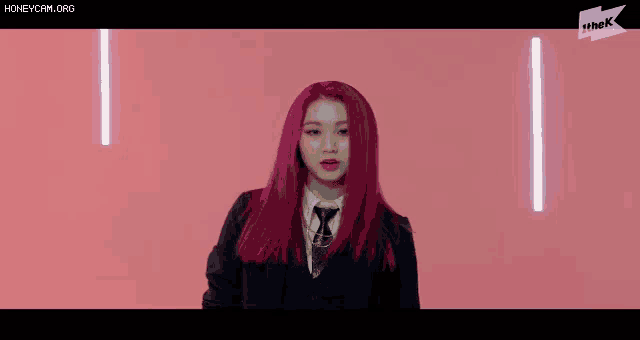 a girl with red hair is wearing a suit and tie .