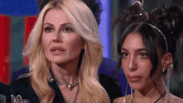 two women are standing next to each other and one has a headband on her hair .