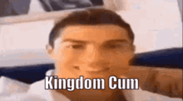 a close up of a man 's face with the words `` kingdom cum '' written on the bottom .