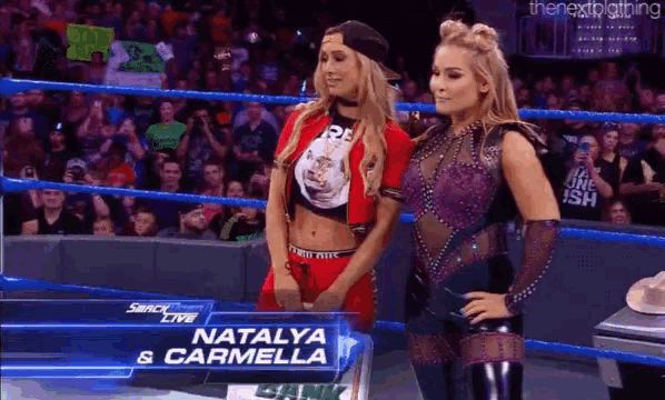 two women are standing in a wrestling ring with the name natalya and carmella