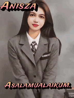 a woman in a suit and tie is standing in front of a wall with a message .