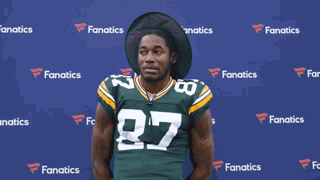a man wearing a green and yellow jersey with the number 27 on it