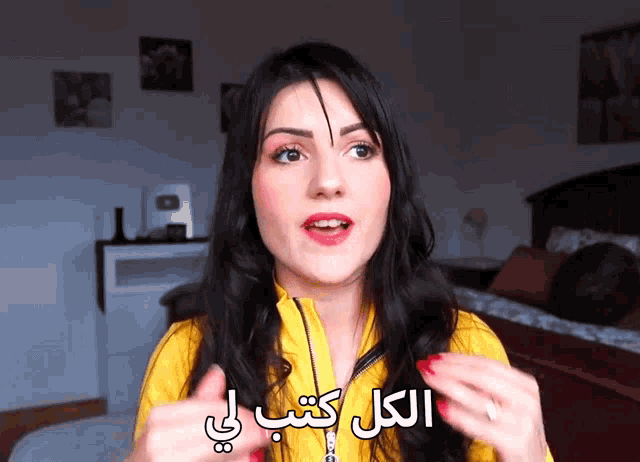 a woman wearing a yellow jacket with arabic writing on her face
