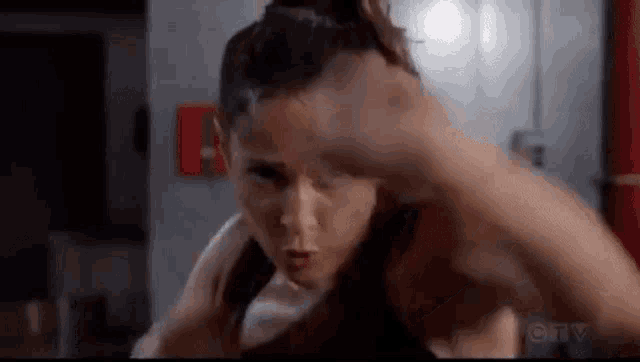 a woman is boxing a man in a gym .